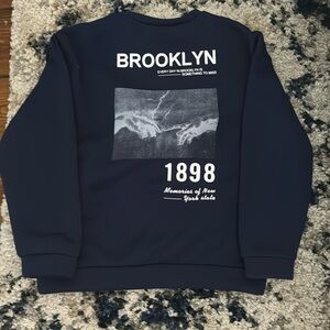 lose fitting, navy blue, detail on the back of crew neck, front is plain.